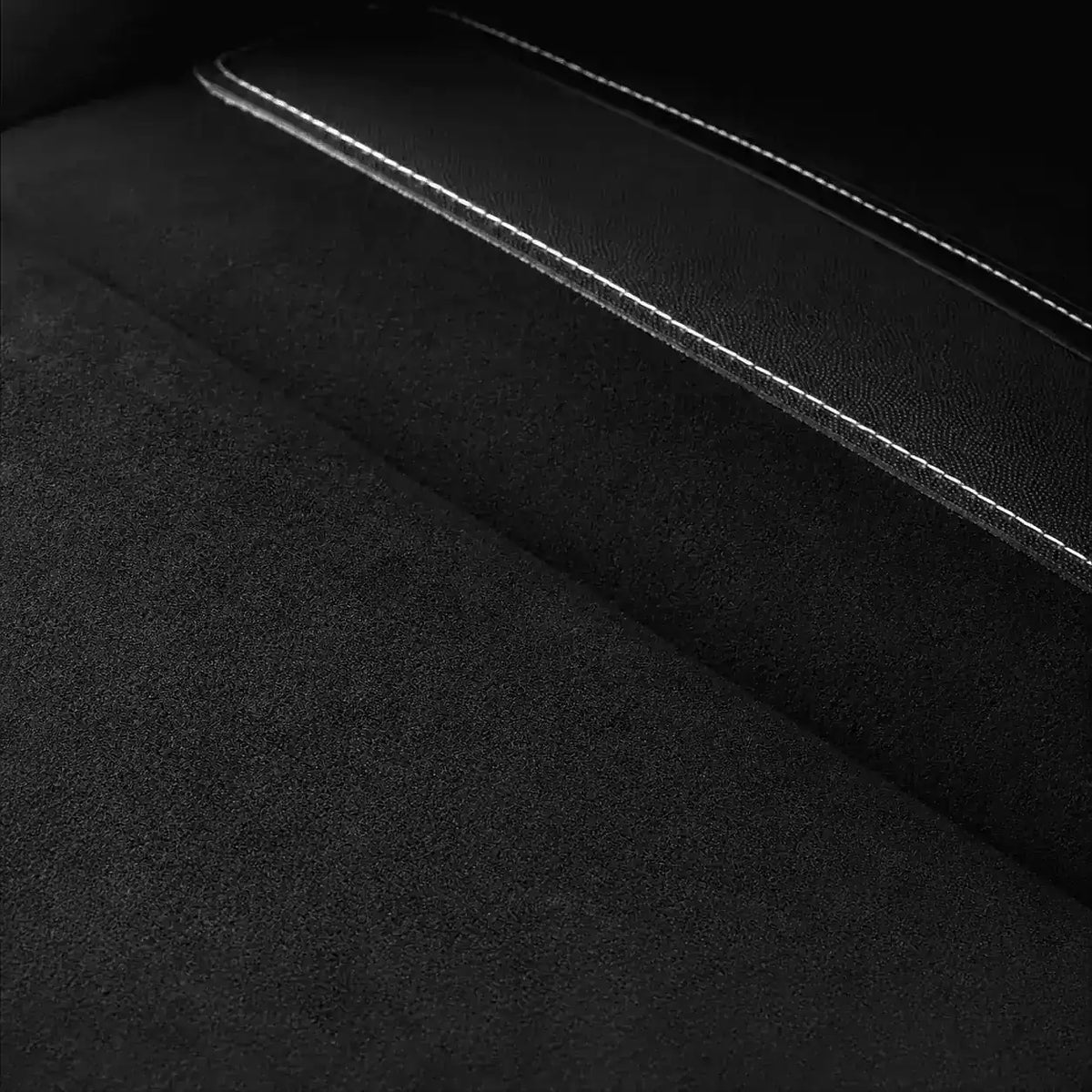 Gros plan sur la matiere noire et les coutures d'une sacoche de velo.