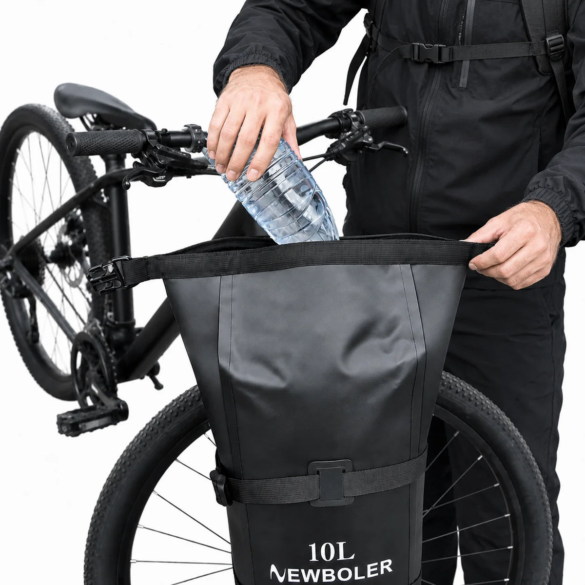 Cycliste glissant une bouteille dans une grande sacoche de vélo noire 10L étanche