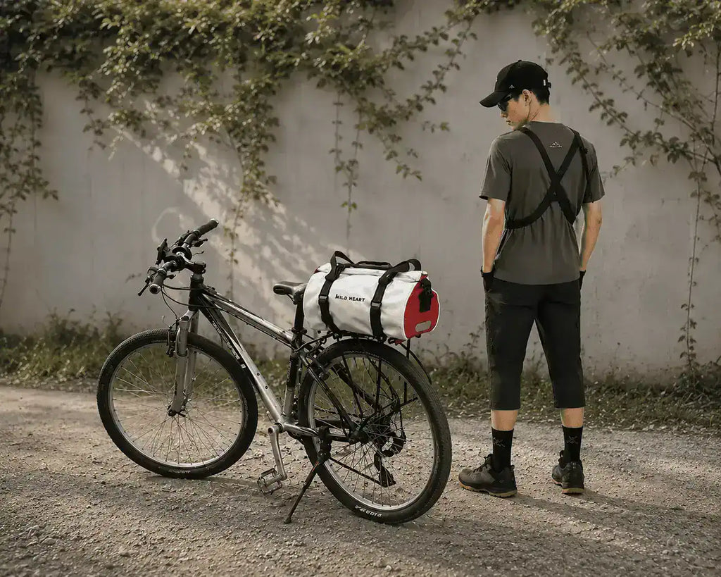 Cycliste à côté d'un vélo équipé de la sacoche 18L sur le porte-bagage arrière