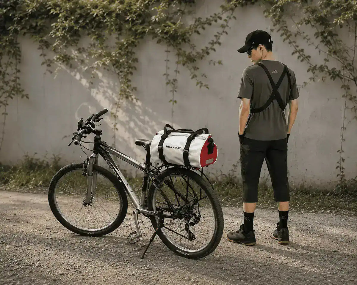 Cycliste à côté d'un vélo équipé de la sacoche 18L sur le porte-bagage arrière