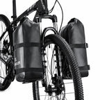 Deux sacoches de fourche noires fixees de chaque cote de la fourche avant d'un velo tout-terrain.