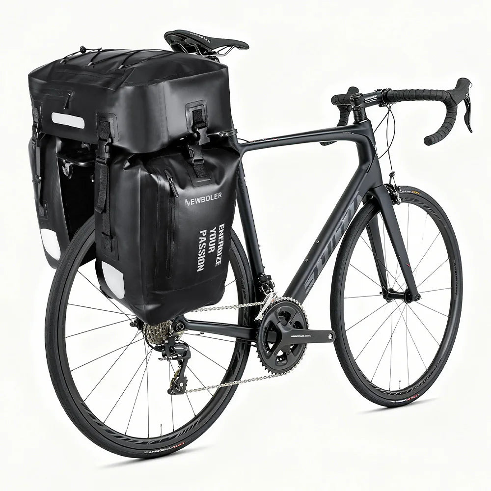 Deux sacoches laterales noires volumineuses fixees sur le porte-bagage arriere d'un velo de route noir.