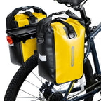 Deux sacoches de porte-bagages jaunes et noires fixees sur le porte-bagages arriere d'un velo.