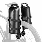 Deux sacoches vélo étanches sanglées sur leurs supports cage, de chaque côté de la roue arrière