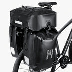 Triple sacoche de porte-bagage noire fixée sur le porte-bagage arrière d'un vélo gris avec bandes réfléchissantes