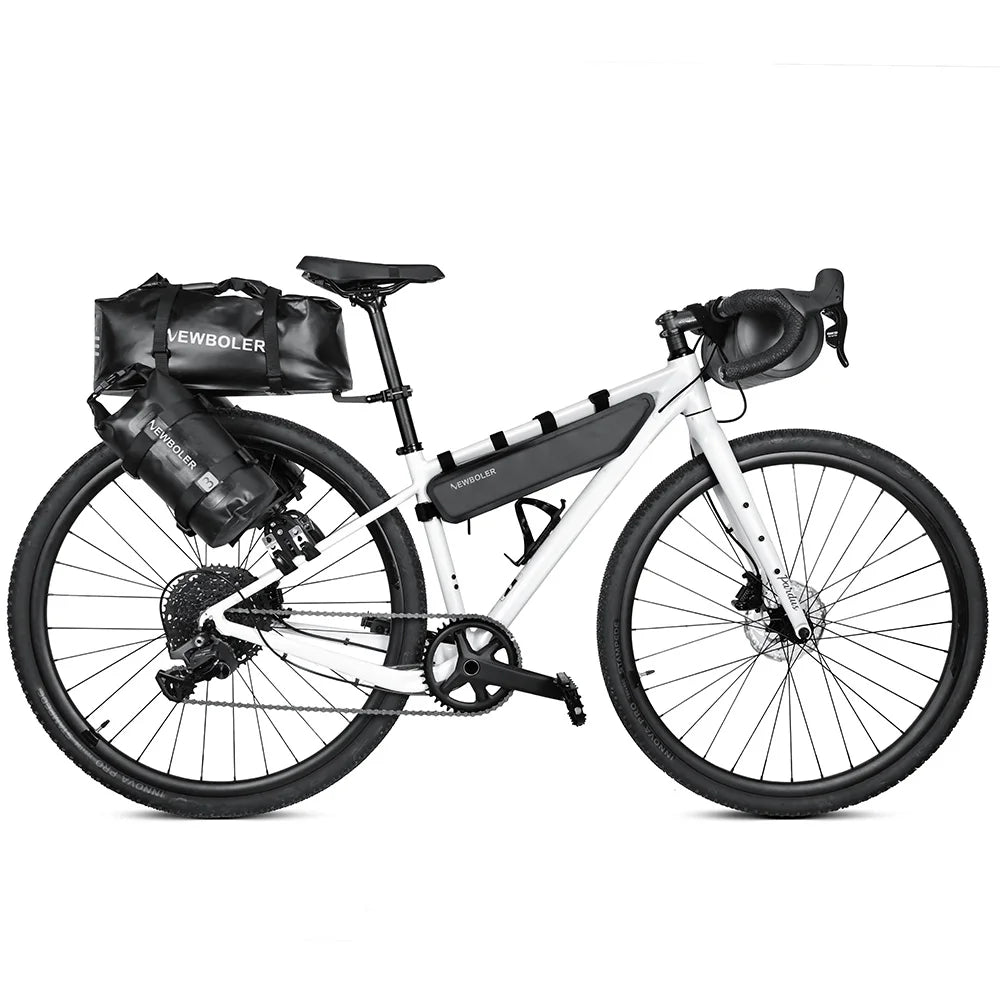 Velo blanc equipe d'un kit complet de sacoches de bikepacking : sacoche de selle, de cadre, de fourche et de guidon.