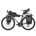 Velo de route noir equipe de plusieurs sacoches bikepacking : sacoche de cadre, de guidon, de selle et deux sacs de fourche.