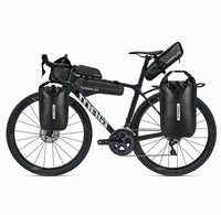 Velo de route noir equipe de sacoches de fourche, de selle et de cadre pour le bikepacking.