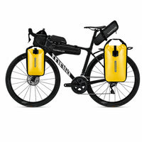 Velo de route noir equipe d'un kit complet de sacoches bikepacking avec deux sacoches de fourche jaunes et sacoches noires