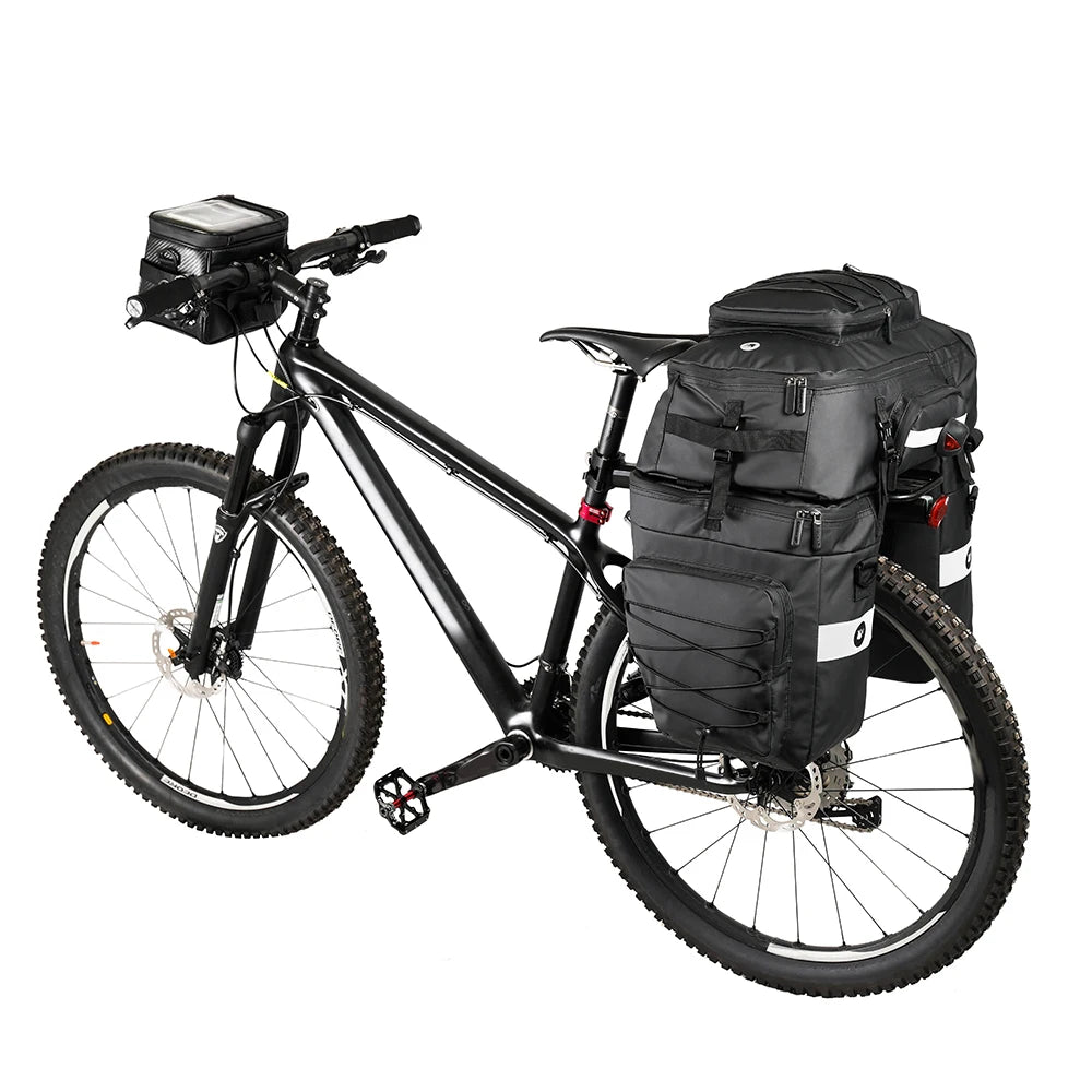 Velo VTT noir equipe d'un set de sacoches noires sur le porte-bagages arriere et d'une sacoche de guidon.